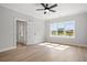 Bright bedroom featuring wood-look floors, white trim, a ceiling fan and a view of the neighborhood through the window at 1201 Possum Trot Rd., North Myrtle Beach, SC 29582