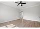 A spacious, neutral bedroom features light wood floors, a ceiling fan, white trim and an open door at 1201 Possum Trot Rd., North Myrtle Beach, SC 29582
