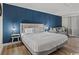 King-size bed in a bedroom with light wood floors and blue accent wall at 1205 S Ocean Blvd. # 50412, Myrtle Beach, SC 29577
