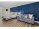 Bedroom with king-size bed, sofa, and blue accent wall at 1205 S Ocean Blvd. # 50412, Myrtle Beach, SC 29577