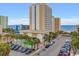 Oceanfront condo building with parking lot and green pool in front at 1205 S Ocean Blvd. # 50412, Myrtle Beach, SC 29577