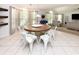 Dining area features a round wooden table, white chairs, and large windows at 1392 Southwood Dr., Surfside Beach, SC 29575