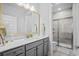 Modern bathroom with gray vanity, quartz countertop, framed mirror, and glass-enclosed tiled shower at 1410 Saw Palmetto St., North Myrtle Beach, SC 29582