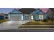 Inviting light blue home with a two-car garage, well-maintained lawn, and colorful sunset background at 1410 Saw Palmetto St., North Myrtle Beach, SC 29582