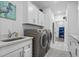 Bright laundry room with washer, dryer, and ample cabinet storage at 1410 Saw Palmetto St., North Myrtle Beach, SC 29582