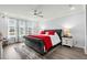 Beautifully staged main bedroom with a ceiling fan, large windows, and a tufted platform bed and a gray accent rug at 1410 Saw Palmetto St., North Myrtle Beach, SC 29582