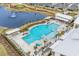 Stunning aerial view of a resort-style pool with lounge chairs, palm trees, and waterfront scenery at 1410 Saw Palmetto St., North Myrtle Beach, SC 29582