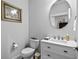 Clean powder room with white vanity and a large round mirror at 1410 Saw Palmetto St., North Myrtle Beach, SC 29582