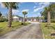 Brick ranch house with palm trees, long driveway, and attached garage at 1530 Deer Park Ln., Surfside Beach, SC 29575