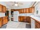 Kitchen features wood cabinets, white appliances, and tile flooring at 1530 Deer Park Ln., Surfside Beach, SC 29575