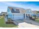 A light blue house with a white garage and a landscaped yard at 1810 N Cove Ct., North Myrtle Beach, SC 29582