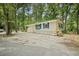 Cozy home with bright blue shutters and neutral siding surrounded by a serene, wooded landscape at 2102 Calabash Circle, Little River, SC 29566