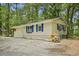 Charming home featuring blue shutters and beige siding nestled in a lush, wooded lot at 2102 Calabash Circle, Little River, SC 29566