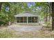 Inviting exterior view of a charming cottage with a screened porch nestled among the trees at 2102 Calabash Circle, Little River, SC 29566