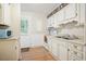 Cozy kitchen with white cabinets and an adjacent door leading to the backyard at 2102 Calabash Circle, Little River, SC 29566