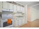 Practical kitchen featuring white appliances, cabinetry and a view into the living space at 2102 Calabash Circle, Little River, SC 29566