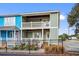 Two-story home with a gray and blue exterior, porch, and landscaping, behind a fence at 2102 S Ocean Blvd. # D, North Myrtle Beach, SC 29582