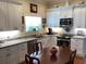 Bright kitchen featuring white cabinets, stainless steel appliances, and a wooden table under a window at 41 Federation Loop, Pawleys Island, SC 29585