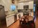 Bright kitchen features white cabinets, stainless appliances, and granite countertops with dining area at 41 Federation Loop, Pawleys Island, SC 29585