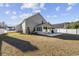 The extended view of backyard features a covered back patio area, white fencing, and a well-maintained lawn at 4821 Southgate Pkwy., Myrtle Beach, SC 29579