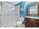 A bathroom featuring blue walls, a vanity, a toilet, and a large glass shower at 4821 Southgate Pkwy., Myrtle Beach, SC 29579