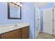 A blue half bathroom with a vanity, a framed mirror, and a shower with a curtain at 4821 Southgate Pkwy., Myrtle Beach, SC 29579