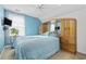The blue bedroom features a bed, a tv, a leafy plant, and an exterior facing window at 4821 Southgate Pkwy., Myrtle Beach, SC 29579