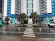 A view of the Bay View Resort entrance with palm trees and stylish design, showcasing easy access at 504 N Ocean Blvd. # 1003, Myrtle Beach, SC 29577