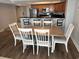 Open dining area with a wooden table and six white chairs, adjacent to the kitchen bar, ready for Gathering dinners at 504 N Ocean Blvd. # 1003, Myrtle Beach, SC 29577