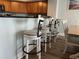 Kitchen with a counter bar featuring four white-cushioned bar stools, perfect for casual dining at 504 N Ocean Blvd. # 1003, Myrtle Beach, SC 29577