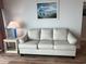 Living room with a comfortable white sofa, beach painting, and stylish decor at 504 N Ocean Blvd. # 1003, Myrtle Beach, SC 29577