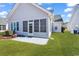 A view of a screened-in porch, green grass, and the rear of a light grey house at 541 Sand Ridge Rd., Conway, SC 29526