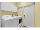 Well-lit laundry room featuring a washer, dryer, white cabinets, and a door at 541 Sand Ridge Rd., Conway, SC 29526