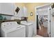 Laundry room with washer, dryer, and cabinets; view of living area at 5522 Elba Way # 5522, Myrtle Beach, SC 29579