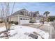 Two-story tan home with white garage doors, nestled in a snow-covered landscape at 6244 Catalina Dr. # 1411, North Myrtle Beach, SC 29582