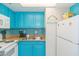 Kitchen with teal cabinets, white appliances, and a double sink at 6804 N Ocean Blvd. # 1637, Myrtle Beach, SC 29572