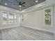 Bright bedroom with tray ceiling, large windows, and neutral walls with hardwood style flooring at 7053 Byrnes Ln., Myrtle Beach, SC 29588