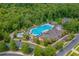 Aerial view of a community pool with lounge chairs, umbrellas, and lush landscaping for relaxation and recreation at 7053 Byrnes Ln., Myrtle Beach, SC 29588
