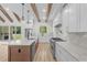 Bright kitchen features a large island, marble counters, stainless appliances, and wooden beam ceiling at 7053 Byrnes Ln., Myrtle Beach, SC 29588