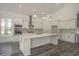 Bright kitchen with stainless steel appliances, white cabinetry, a large island, and modern lighting at 7053 Byrnes Ln., Myrtle Beach, SC 29588