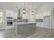 Modern kitchen with white cabinets, gray island, stainless steel appliances, and hardwood floors at 7053 Byrnes Ln., Myrtle Beach, SC 29588