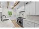 Gourmet kitchen with marble countertops, stainless steel oven, and modern white cabinets with gold hardware at 7053 Byrnes Ln., Myrtle Beach, SC 29588