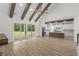 Open-concept living area with wood floors, vaulted ceiling, and adjacent kitchen featuring an island and modern appliances at 7053 Byrnes Ln., Myrtle Beach, SC 29588