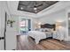 Serene main bedroom featuring a decorative tray ceiling, sliding glass door, and an ensuite bathroom at 7053 Byrnes Ln., Myrtle Beach, SC 29588