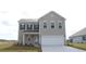 Two-story house with gray siding, a two-car garage, and landscaping at 7073 Shooting Star Way, Myrtle Beach, SC 29579