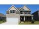 Two-story house with neutral siding, stone accents, and a two-car garage at 7075 Shooting Star Way, Myrtle Beach, SC 29579