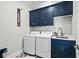 Bright laundry room, featuring stylish navy cabinets and modern washer/dryer set at 744 Crystal Water Way, Myrtle Beach, SC 29579