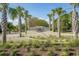 Community entrance with palm trees and a landscaped median at 9237 Bellasara Circle, Myrtle Beach, SC 29579