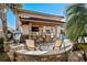 Outdoor kitchen with stone bar, seating, and adjacent pool at 9237 Bellasara Circle, Myrtle Beach, SC 29579