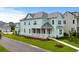 Two-story light green house with a front porch and landscaped yard in a neighborhood setting at 946 Crystal Water Way, Myrtle Beach, SC 29579